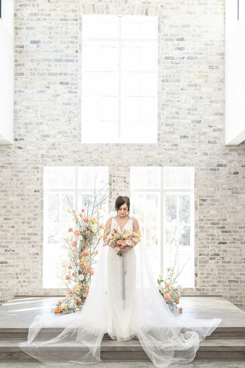 Light and Colorful intimate wedding inspiration_C_low. Baron Photography_The-Peach-Orchard-Weddings-Woodlands-TX-C-Baron-Photo-148 bride standing at the ceremony with peach flowers