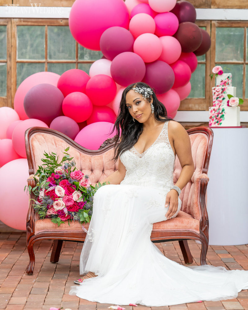 bright and bold pink wedding theme36 Bride sitting on a sofa surrounded by pink balloons