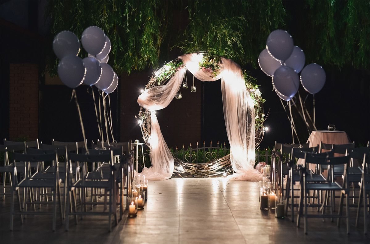 A-garden-style-wedding-balloon-arch-woven-with-trailing-eucalyptus-and-soft-ivory-balloons-framing-a-ceremony-aisle A garden-style wedding balloon arch woven with trailing eucalyptus and soft ivory balloons framing a ceremony aisle